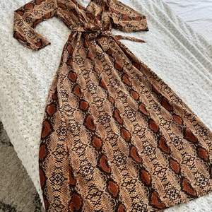 Ormmönstrad klänning i strl 38/40. Ny!!! - Omrmönstrad klänning. Uppskattad strl 38/40. Oanvänt!! Nypris 599kr.