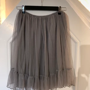 Tyllkjol  - Säljer denna oanvända gråa tyllkjol! Superfint skick men har bara inte kommit till användning🌟 Finns resår i midjan och passar därför fler storlekar 