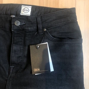 ASOS Slitna svarta jeans (Nyskick) - Svarta jeans med hål i knäna. Jeansen är endast prövade men var för små vilket är anledningen till att dem nu säljs
