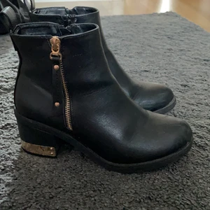 Boots - Säljer dessa fina klackskor med guldkant då dom inte kommer till användning längre, klacken är 5cm. Har använt dom 2 eller 3 gånger. De är inget fel på dom vad jag ser, köpte dom på din sko för typ 499kr eller något 
