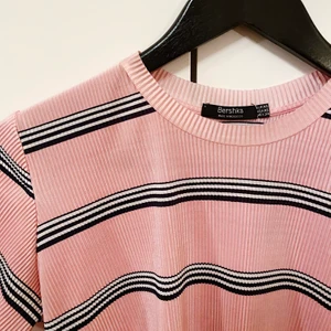 Topp Bershka  - Säljer en T-shirt i glansigt, lite räfflat tyg, från Bershka. Oanvänd. Köparen står för frakt