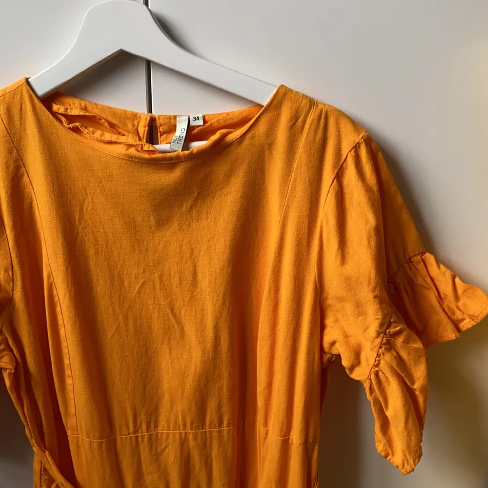 Orange fin klänning med volanger och knyte i midjan i linneaktigt tyg. Storlek 34. Från nelly. Klänningar.