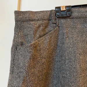 Fiskbensmönstrad kjol - Ullkjol i fiskbensmönster. Svart och vit med fickor och hylsor för skärp.Kan mötas upp eller skicka på posten(köpare betalar frakten). Samfraktar gärna om du köper flera plagg!