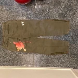 Armyjeans/chinos  - Armegröna jeans/chinos med coola detaljer. Blixtlås nertill. 
