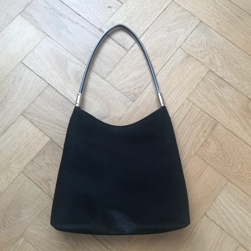 Svart väska från Forelli, unikt svart tyg men lite glitter/glanstrådar i. Handtag i plast. Köpt secondhand. 23x21cm. Väskor.