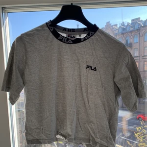 FILA croptop - En grå mjukis croptop från FILA 💙❤️ Använd max 2 gånger, lite skrynklig pga inte vikt efter tvätt men stryker man/tvättar går det av direkt. Den är så fin och bekväm men har tyvärr knappt fått användning så behöver ett nytt hem! 80kr och i storlek M 🥰