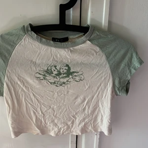 Grön & gräddvit t-shirt med tryck.  - Bra skick knappt använd. Tunt tyg. 