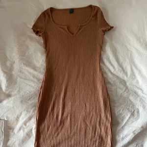 Helt ny beige klänning strl S - Helt ny beige ribbad klänning i storlek S. Detalj i halsringningen samt volangdetaljer vid ärmslut och nederdel av klänning. Tajt och figurnära🥰 frakt 52kr