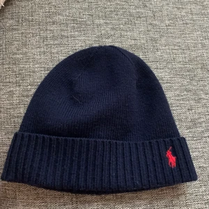 Polo Ralph Lauren mössa  - Polo mössa , köpt på kidsbarndstore, ny pris 500kr, aldrig använd. Har bara provat den en gång,