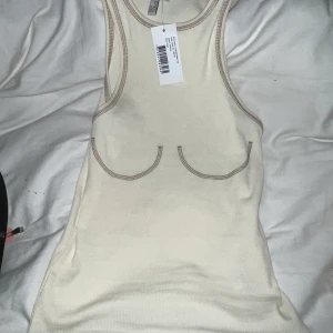 Nelly - Ett linne med detalj vid brösten