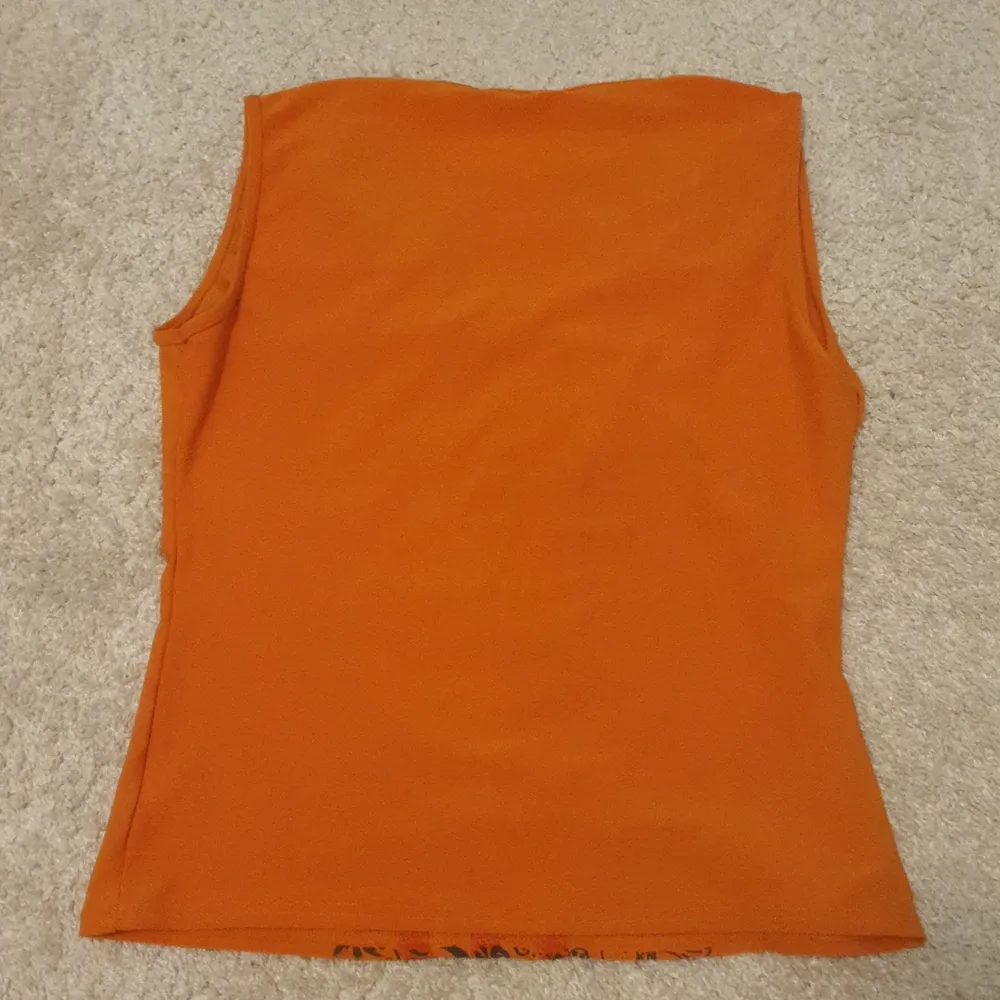 Ett oranget vintage-linne från ICHI. Storlek L men passar på S och M. Bra skick. Material: polyester/elastin. Skriv vid intresse!. Toppar.