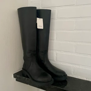 Höga stövlar - Säljer ett par oanvända klassiska stövlar i läderimitation från Bershka. Köptes från Zalando i höstas för 899 kr men säljer då de inte kommer till användning. Slutsålda online!