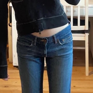 Lågmidjad bootcut/straight jeans - Mörkblåa lågmidjade/midrise bootcut jeans med motiv på bakfickorna. Så himla snygga men lite stora för mig. Waist 28