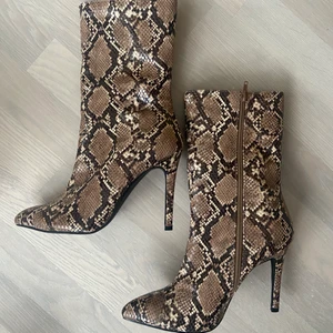 Stilettklackar, strl 40.  - Klackar från NAKD, ormimitation. Strl 40, oanvända. Köparen står för eventuell frakt om det inte går att mötas upp i umeå eller bispgården/östersund.