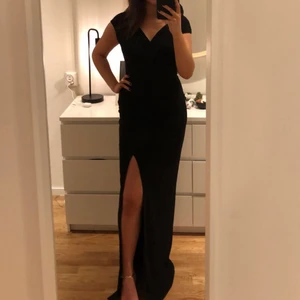 Svart elegant långklänning - Jättefin och smickrande långklänning i svart färg från Nelly. Använd 1 gång, nyskick. Älskade verkligen klänningen, satt perfekt och var så bekväm!