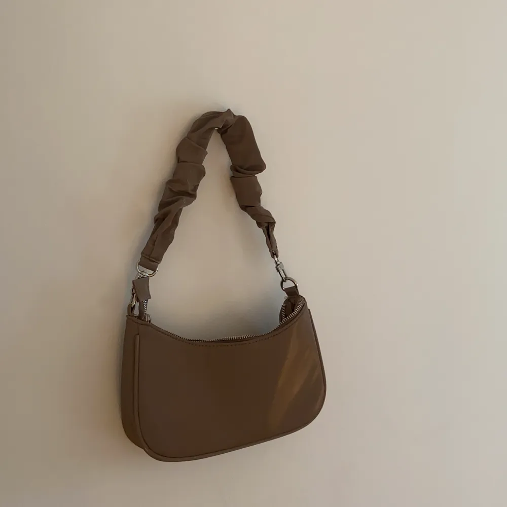 Säljer denna brun-beiga coola väska. Väskans material är något glansigt. Använd få gånger och säljs för 80kr+ frakt👜🤎. Väskor.