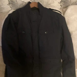 Jacka  - Saknar knapp på ena axeln 