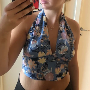 Blommig halted neck topp - Blommig topp med öppen rygg. I storlek S. 