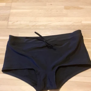 Badtrosa  - Svart bikiniunderdel från stadium. Den har knytning i midjan