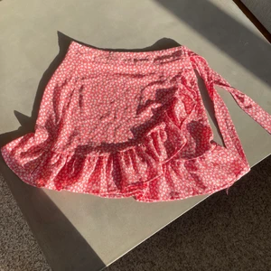 Kjol  - Sommarkjol! Jättesöt röd kjol med vita små blommor perfekt till sommaren. Kommer tyvärr inte till användning. Som ny använt få gånger. Storlek XS! 