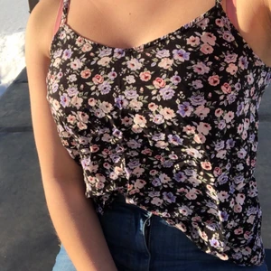 Blommigt linne - Svart blommigt sommar linne med tunna remmar. Inge mycke stretch utan den sitter som den sitter, rekommenderar inte om du har en lite större byst. Rätt liten i storlek i och med att de inte är nån stretch.