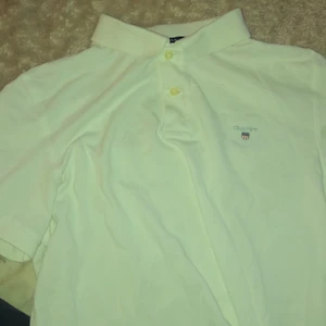 Gant pikétröja vit - Hej säljer min fina pikétröja från gant. Tröjan är lite skrynklig som ni ser på bilden men stryks såklart innan leverans. Cond:10/10. Storlek: L