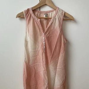 Skönt rosa linne från Noa Noa - Fint längre linne från Noa Noa i rosa och vitt. Vackra knappar framtill. Storlek XS. Materiallapp saknas men troligen 100% bomull. Den är lite smånopprig på ena sidan och har gulnat pyttelite under ena armen. I övrigt skrynklig då den har legat nedvikt. Fortfarande jättefin och mycket skön under varma sommardagar!