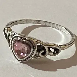 Silverring med en rosa kristall i form av en hjärta. 