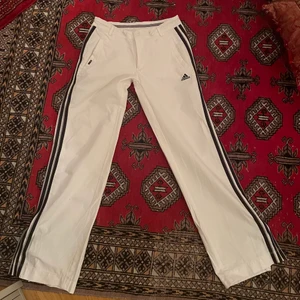 Adidas byxor - Vita adidas byxor. Passar mig som bär storlek s men skulle passa en xs också. Lågmidjade med dragkedjor vid vristerna💕