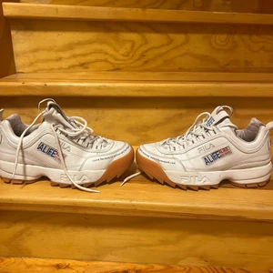 Fila skor - Annorlunda vita fila distruptor skor som är i kollabration med street märket Alife från New york. Skorna är lite slitna men fof väldigt coola. Skorna är i storlek 39 men skulle även säga att de passar för någon med 38. Köparen står för frakten :)