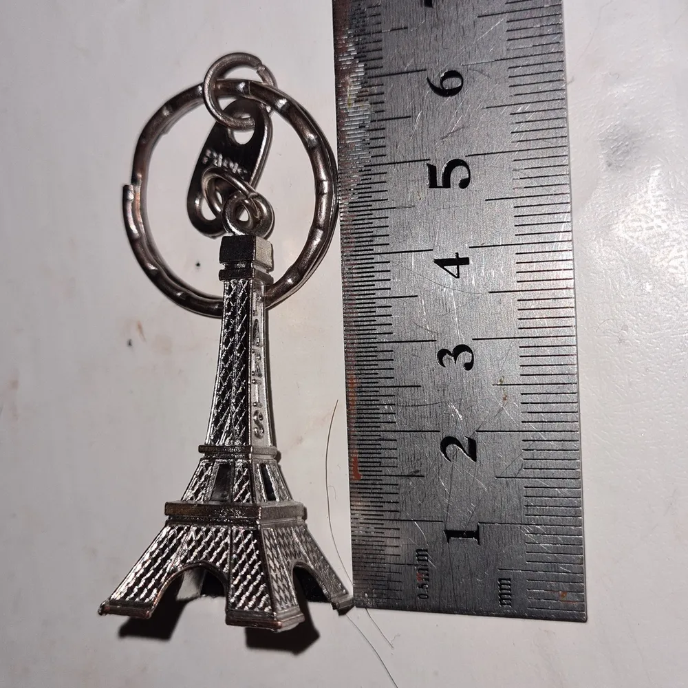 En silvrig nyckelring en miniatyr av eiffeltornet. . Accessoarer.
