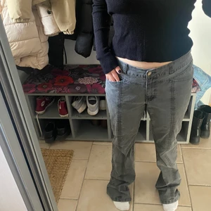 Lågmidjade gråa jeans - Ett par gråa lågmidjade jeans med coola detaljer på benen och bakfickorna🙌🏻🙌🏻Lappen är borta så vet inte exakta strl men passar mig som brukar ha M❤️