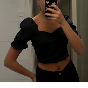 Svart topp från hm - Säljer denna snygga topp med öppen rygg och puffärmar från Hm! ⭐️⭐️ Svart och i storlek XS