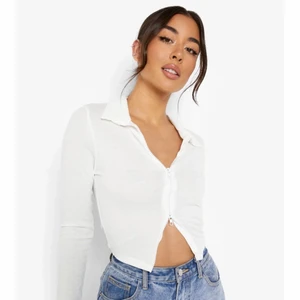 Boohoo topp med två dragkedjor  - Helt ny och oanvänd vit topp med 2 dragkedjor och krage. Köpte tröjan för några dagar sen från Boohoo men får tyvärr inte ens på mig den eftersom den är för liten för mig. (Därför behövde jag låna den 1 bilden från Boohoos hemsida). Den har stoleken 34 och denna storleken är helt slutsåld i boohoos hemsida så snabba dig för den är precis som en nyköpt tröja från Boohoo fast billigare. (Boohoo påsen och lappen är kvar) opps! köparen står för frakten.  
