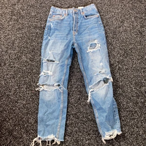 Hm divided jeans storlek 36. - Mörkblåa högmidjade jeans med hål och knapp gylf. Storlek 36