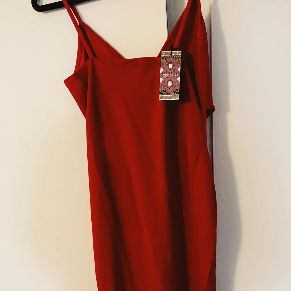 Ännu en till röd snygg klänning från Boohoo! Lite urringat med en slit på sidan 🥰 Aldrig använd! Köparen står för frakt eller mötas upp i Malmö 🎊. Klänningar.