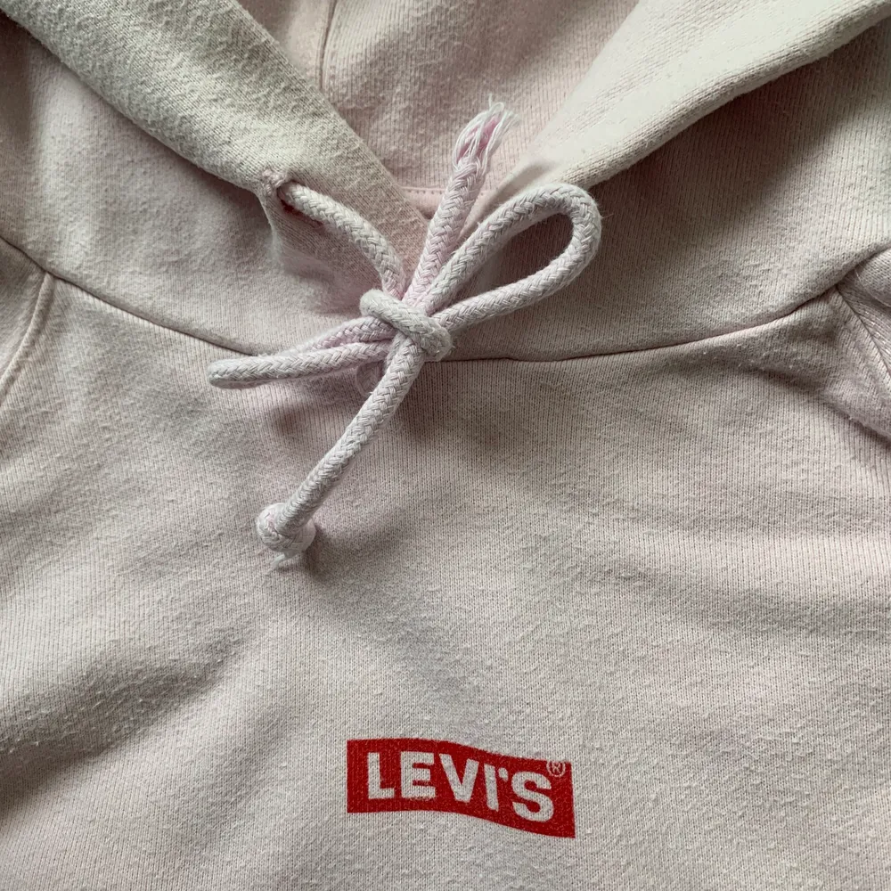 Säljer en ljusrosa Levis hoodie som inte kommer till användning. Andra bilden beskriver färgen bäst💗 På sista bilden kan ni se att knuten på snöret har gått upp så att det är lite spretigt✨ Pris kan diskuteras, NYPRIS: 800kr. Hoodies.