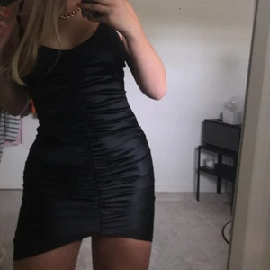 Festklänning - As snygg festklänning i svart med reglerbara Axel band och en dragkedja där bak. Formar kroppen snyggt. Från Nelly.com
