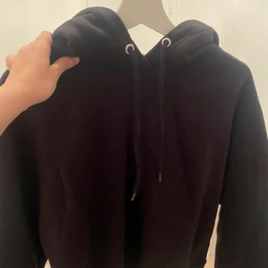 Svart hoodie i stl M - En svart vanlig lite kortare hoodie vid magen, den är skön och perfekt till hösten/vintern. Säljs för 80kr. Frakt tillkommer och betalning sker via swish.