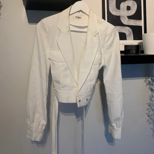 Croppad blazer - Super snygg croppad blazer med bälte som tyvärr är för liten för mig, använd en gång. Den har lite smink runt kragen men går bort i tvätten