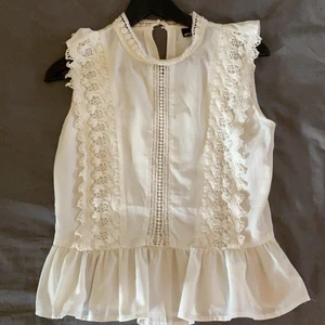 Vit volangtopp - Jag säljer en vit topp med volang från Gina Tricot pågrund av att den är för liten. Den är nästan aldrig använd och därför nästan som ny. 