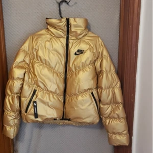 Nike puffer jacka - Säljer min ÄKTA nike puffer jacka i guld denna gång pågrund av att jag aldrig har på mig den! Pris kan självklart diskuteras vid snabb affär 🤍