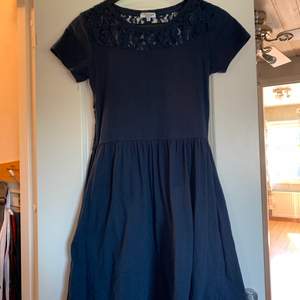 Marinblå klänning i storlek S. Spets vid nyckelbenen framtill och på hela ryggen, även fickor i kjolen. Ny pris: 300kr, bud från 100kr☺️