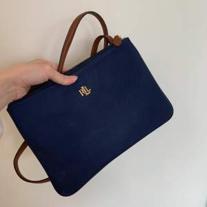 Marinblå väska med guld detaljer och brunt band från ralph lauren! 