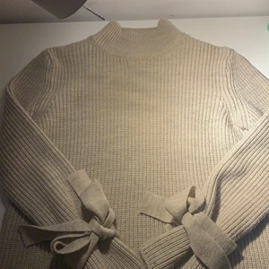 Musik beige stickad tröja ifrån Gina  - Ganska använd, länge sen den köptes, bra skick, mysig, snygg, själv för att jag inte trivs i polotröjor. 