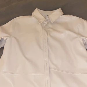 Skjorta i fakeläder - Vit skjorta i fakeläder. Den är gräddfärgad vit. Supersnygg och passar både som tröja och övertröja🥰🥰