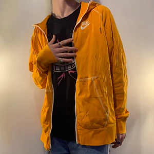 Vintage orange Nike zip hoodie oversized - Vintage orange oversized Nike zip up hoodie med vit dragkedja, logga och kontrast stitching 🧡 Denna hoodien är så himl skön och är ett perfekt alternativ för dig som vill ha en casual men ändå utstickande hoodie att slänga över en skön outfit! En av de bästa detaljerna tillsammans med den vita contrast stitchingen som gör hoodien mer unik och genomtänkt är definitivt att dragkedjan har Nike loggan på sig i metall vilket är en sån sjukt snygg extra detalj!