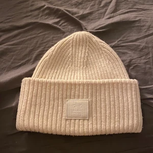 Acne mössa vit - Köpte denna acne mössa på acne studios från Nk i Stockholm. För ca 3-4 år sedan. Men som ni ser så är den väldigt sparsamt använd. Ser fortfarande ut som ny. Nypris 1100 kr