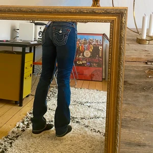 True Religion lågmidjadejeans - Som nya, otroligt fina och rare detaljer!!! Har inte fått någon användning av jeansen som jag trodde därav tagen kvar sen köp. Köpta här på plick för 690kr så kan tänka mig sälja dem direkt för 500kr. ‼️‼️Vid högt intresse startar jag BUDGIVNING. I kommentarsfältet med start på 300kr, höj minst 20kr varje bud‼️‼️‼️  Strl 25 och passar mig perfekt som är 25-26 eller 34-36. Är 168 cm lång.