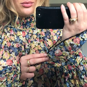 blommig blus - säljer denna supersöta blus med färgglada blommor i tunt tyg med textur ni ser på sista bilden. helt oanvänd med lappar kvar, tyvärr inte mina färger :(